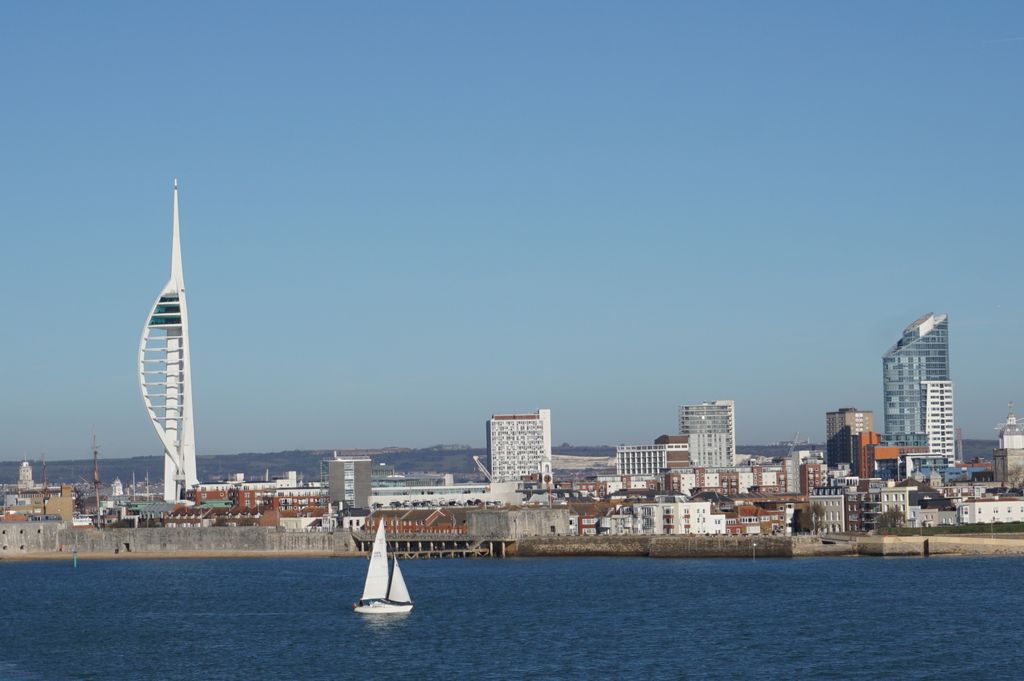 Stunning view of Portsmouth's skyline featuring the iconic Spinnaker Tower with a sailboat in the foreground.