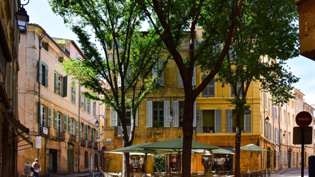 Picturesque street corner in Aix-en-Provence, showcasing traditional architecture and vibrant outdoor café setting.